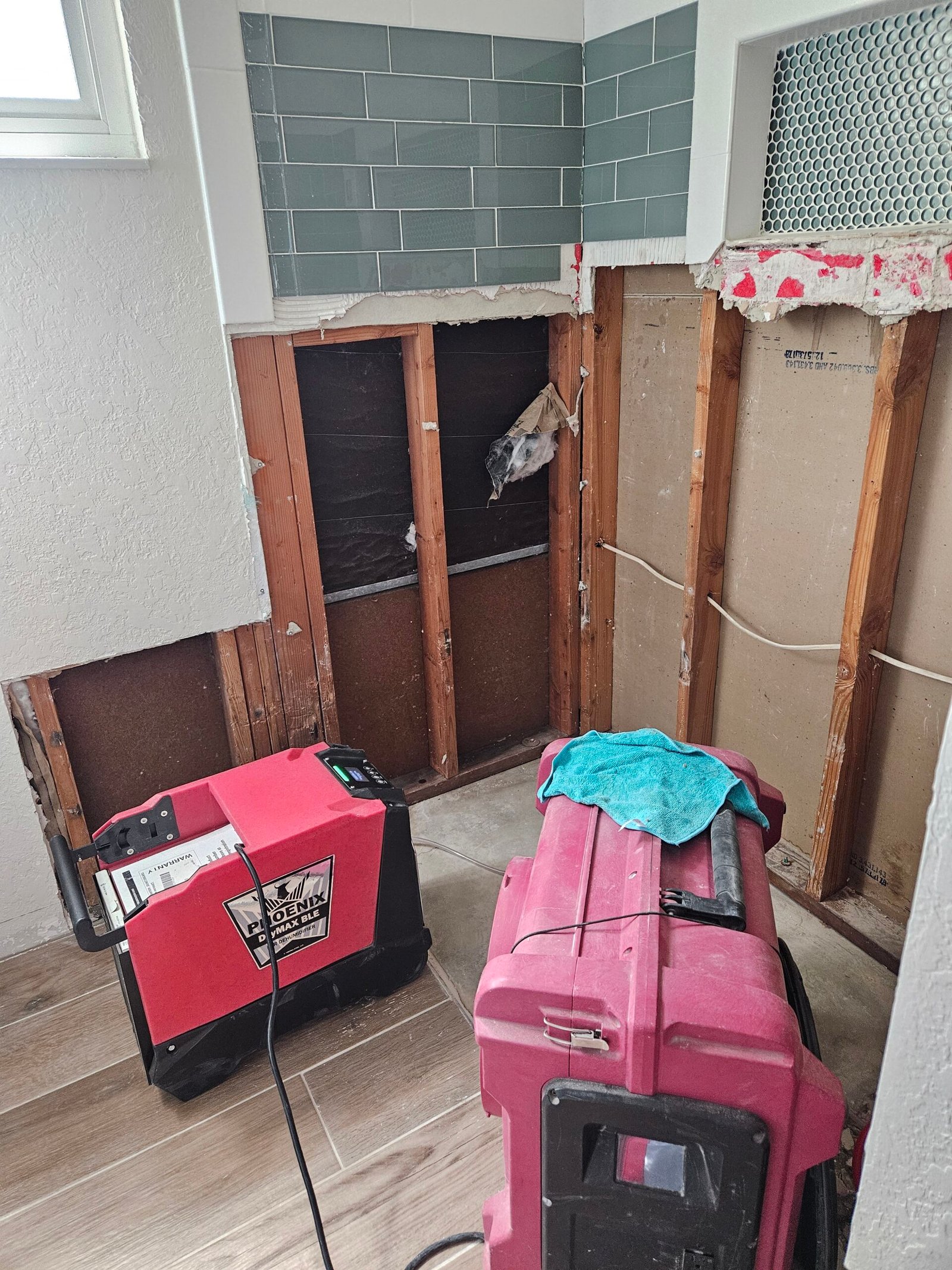 Drying and air-filtration equipment beside exposed bathroom wall framing in Los Banos.
